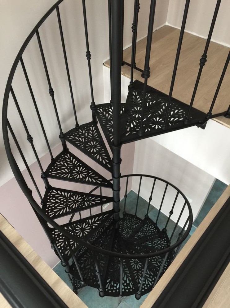 На фото: маленькая винтовая лестница в стиле неоклассика (современная классика) с металлическими ступенями и металлическими перилами для на участке и в саду с