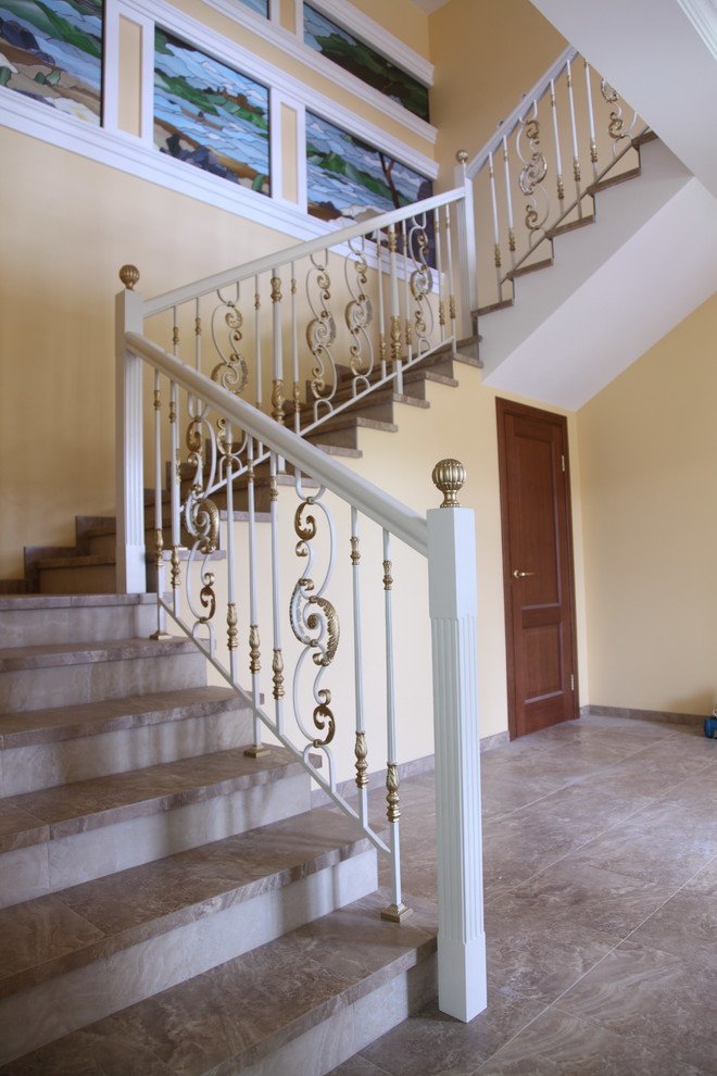 Foto de escalera en U mediterránea grande con escalones de mármol, contrahuellas de mármol y barandilla de madera