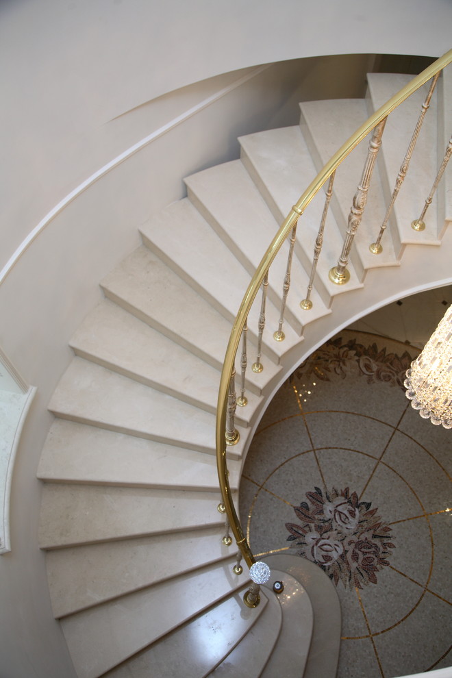 Photo of a large mediterranean marble curved staircase in Moscow with marble risers and metal railing.