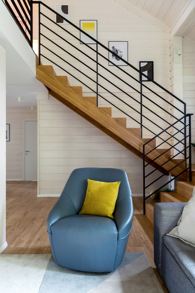 На фото: п-образная деревянная лестница среднего размера в скандинавском стиле с деревянными ступенями и металлическими перилами