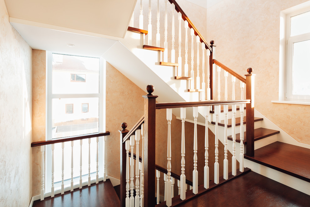 Ejemplo de escalera clásica de tamaño medio con escalones de madera, contrahuellas de madera y barandilla de madera