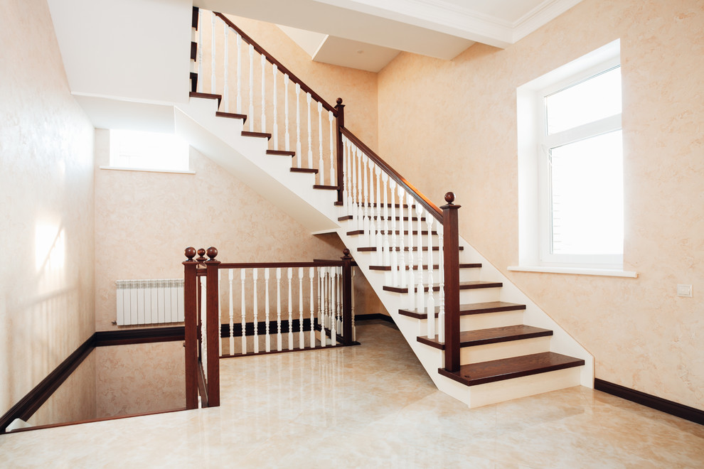Idée de décoration pour un grand escalier tradition avec des marches en bois, des contremarches en bois et un garde-corps en bois.