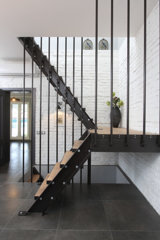 Идея дизайна: п-образная лестница в стиле лофт с деревянными ступенями без подступенок