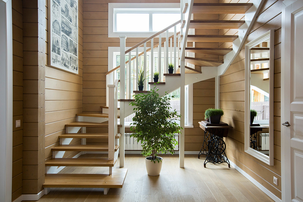 Diseño de escalera en U de estilo de casa de campo sin contrahuella con escalones de madera