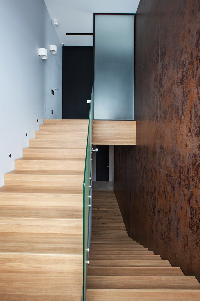 Свежая идея для дизайна: большая п-образная деревянная лестница в современном стиле с деревянными ступенями и стеклянными перилами - отличное фото интерьера