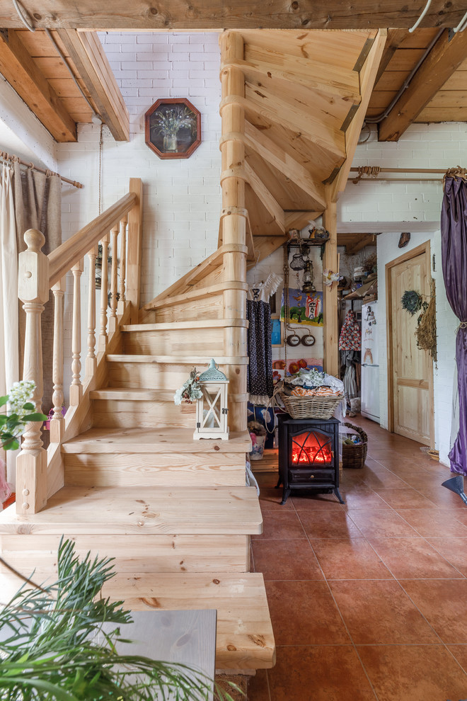 Diseño de escalera curva campestre con escalones de madera, contrahuellas de madera y barandilla de madera