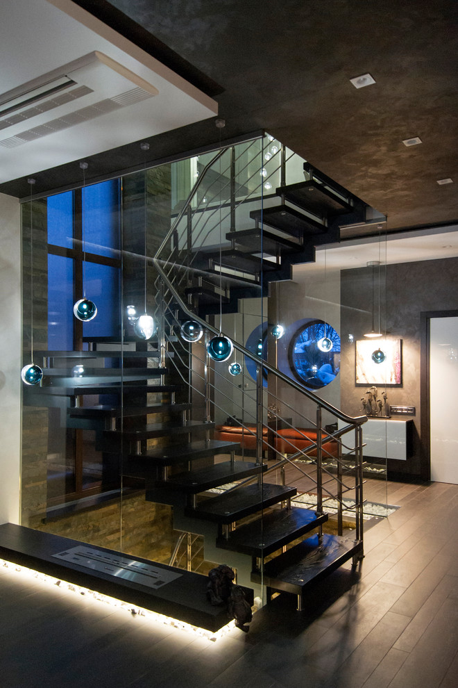 Gewendelte, Mittelgroße Moderne Treppe mit offenen Setzstufen und Stahlgeländer in Sonstige