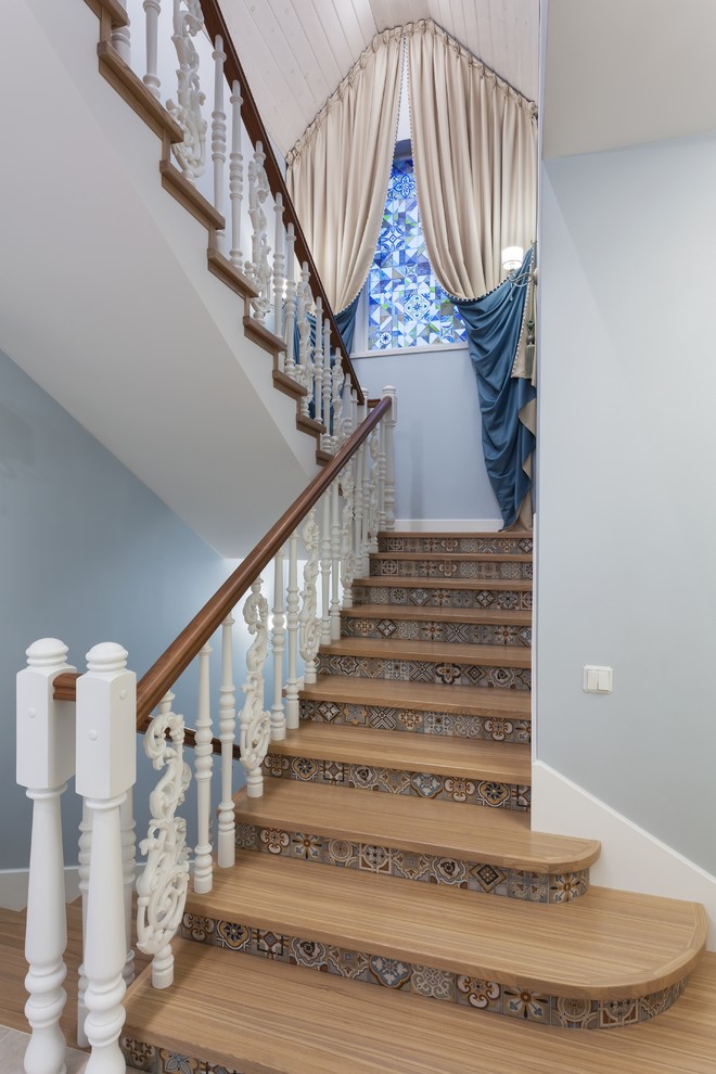 Стильный дизайн: п-образная лестница в средиземноморском стиле с деревянными ступенями, подступенками из плитки и деревянными перилами - последний тренд