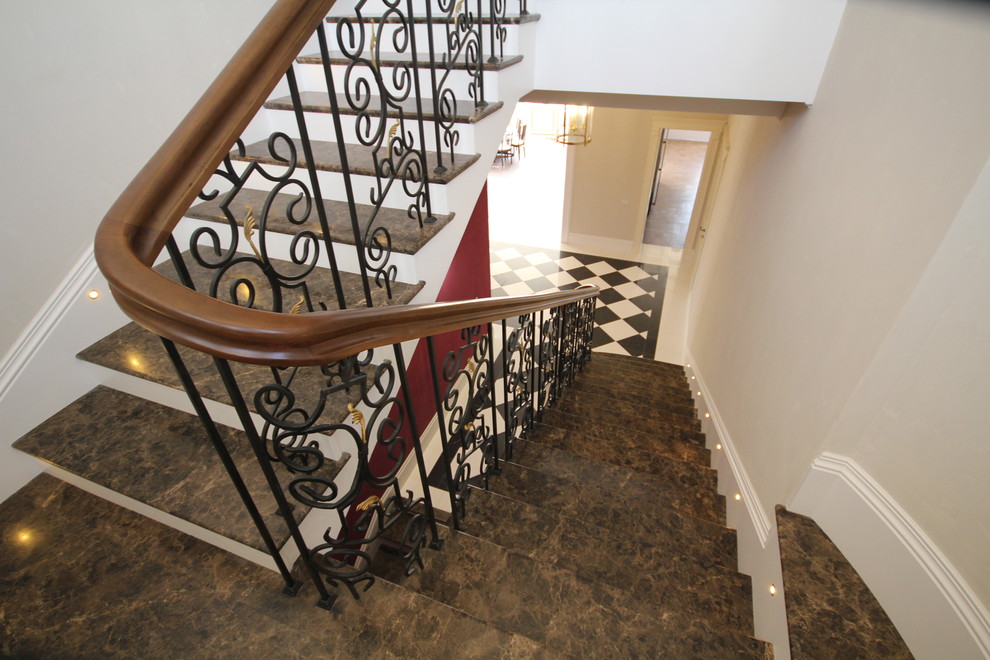 Стильный дизайн: большая п-образная деревянная лестница в классическом стиле с мраморными ступенями и металлическими перилами - последний тренд