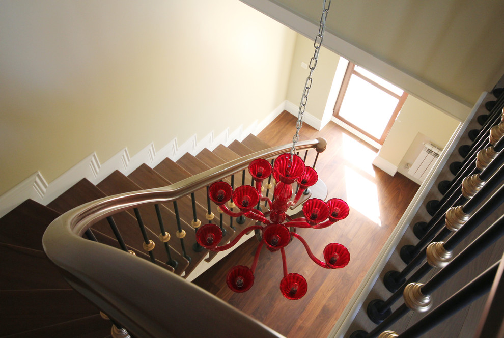 Diseño de escalera en L clásica de tamaño medio con escalones de madera, contrahuellas de madera y barandilla de metal