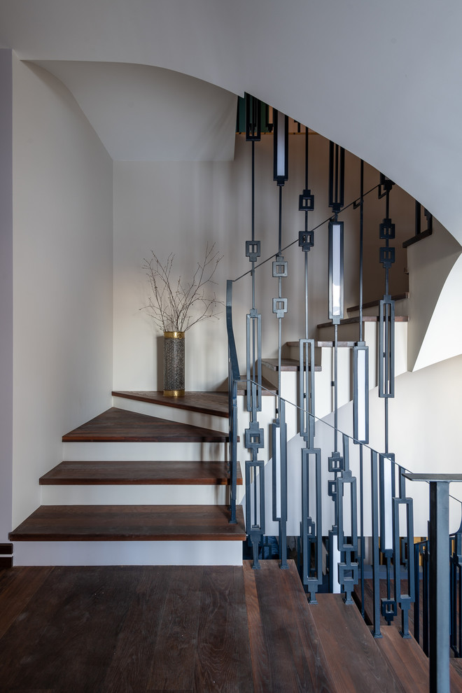 Imagen de escalera contemporánea con escalones de madera y barandilla de metal