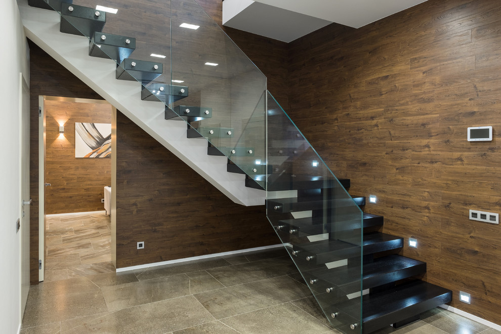Пример оригинального дизайна: угловая лестница в современном стиле с стеклянными перилами