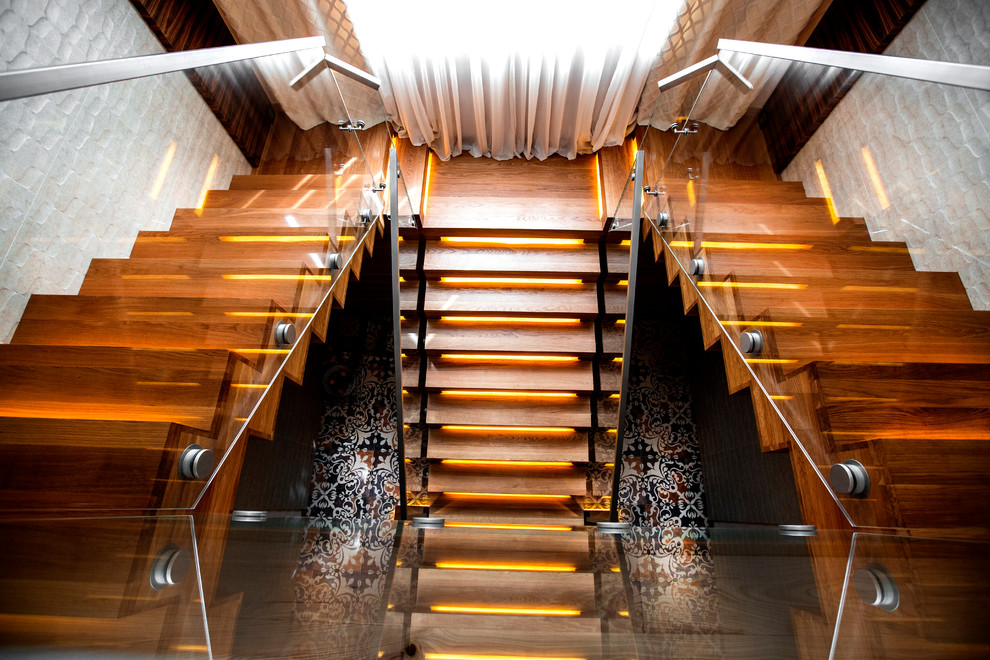 Пример оригинального дизайна: п-образная деревянная лестница в современном стиле с деревянными ступенями и стеклянными перилами