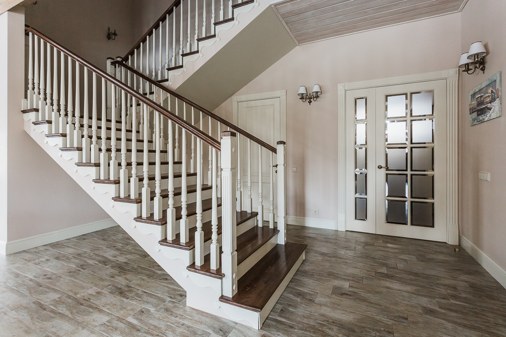 На фото: прямая деревянная лестница среднего размера в классическом стиле с деревянными ступенями, деревянными перилами и обоями на стенах