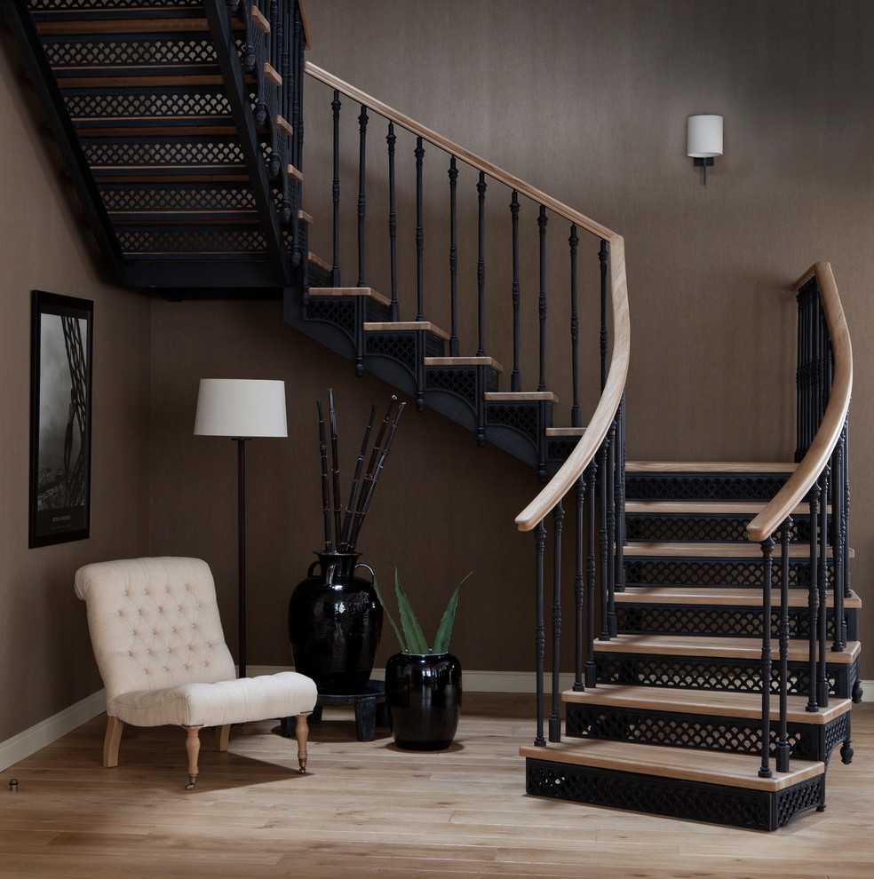 Aménagement d'un escalier classique en U avec des marches en bois, des contremarches en métal, un garde-corps en matériaux mixtes et éclairage.