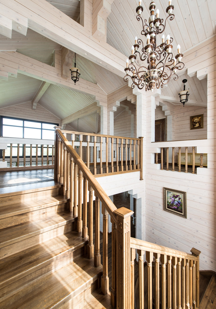 Photo of a rural wood u-shaped wood railing staircase in Moscow with wood risers.