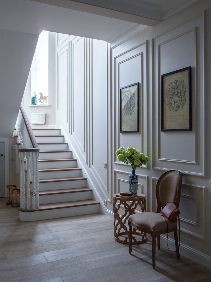 На фото: лестница среднего размера в классическом стиле с деревянными перилами с