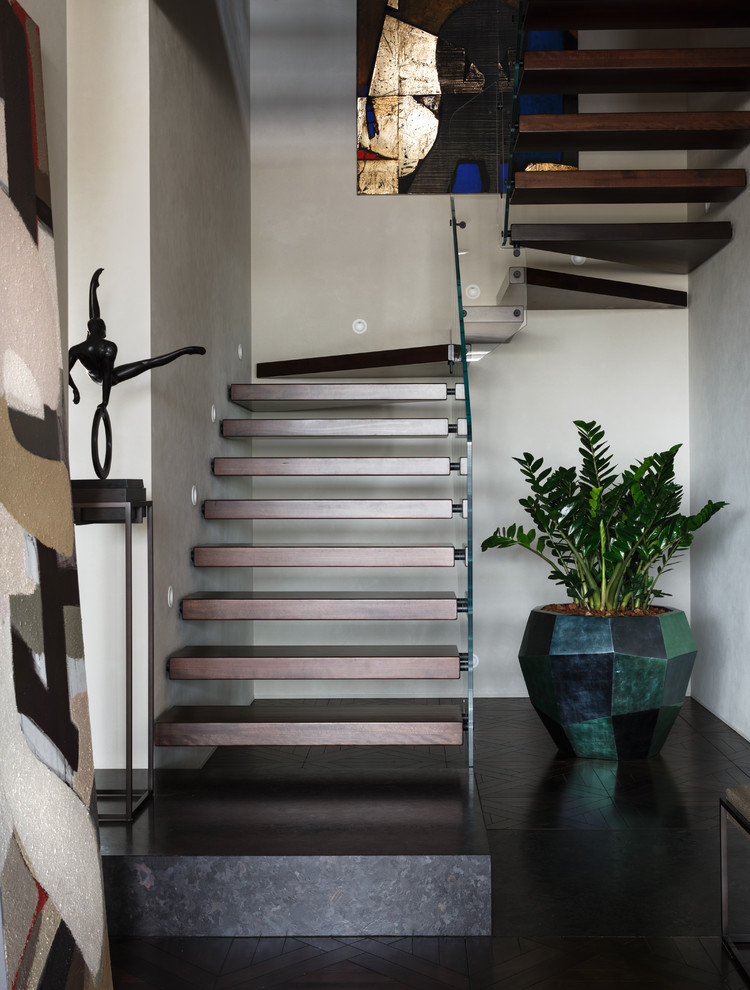 Idée de décoration pour un escalier sans contremarche design en U avec des marches en bois et un garde-corps en verre.