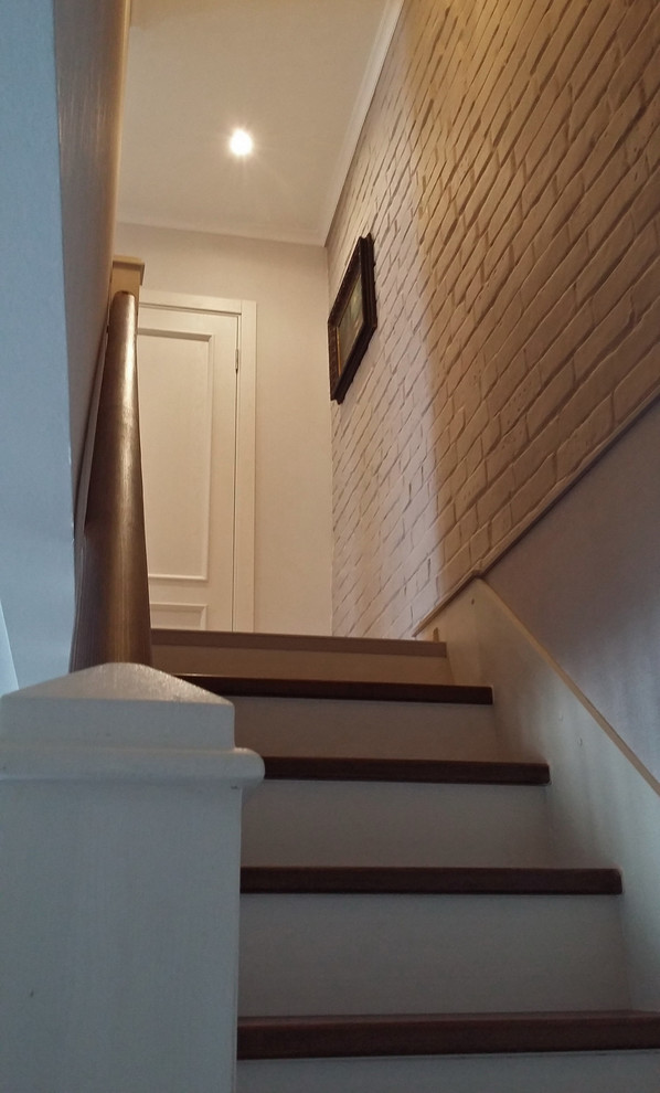 サンクトペテルブルクにあるお手頃価格の小さなコンテンポラリースタイルのおしゃれな直階段 (木の蹴込み板、木材の手すり) の写真