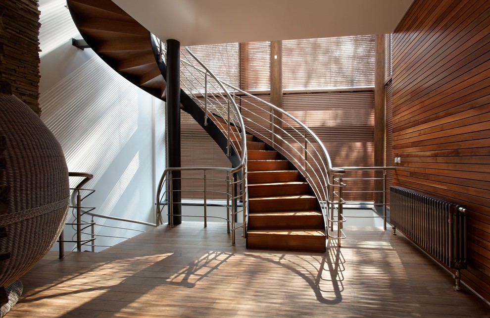 Modelo de escalera curva contemporánea con escalones de madera y contrahuellas de madera