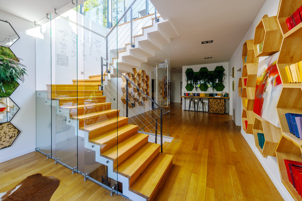 Свежая идея для дизайна: угловая деревянная лестница в стиле фьюжн с деревянными ступенями и металлическими перилами - отличное фото интерьера