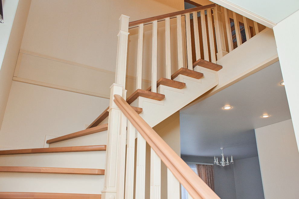 Стильный дизайн: угловая деревянная лестница с деревянными ступенями и деревянными перилами - последний тренд