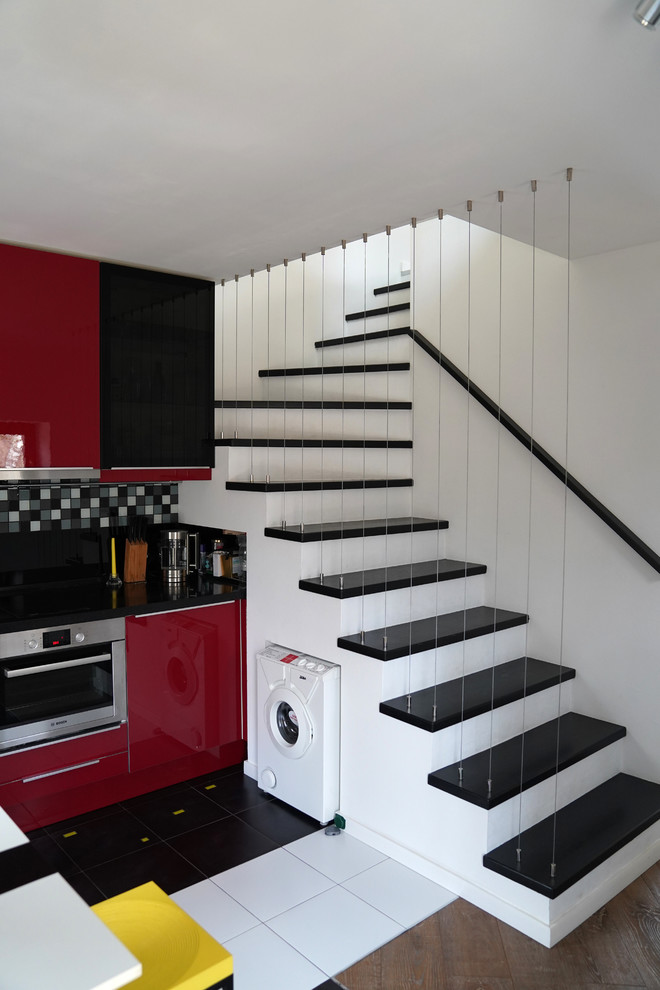 Свежая идея для дизайна: маленькая изогнутая лестница в современном стиле с перилами из тросов и кладовкой или шкафом под ней для на участке и в саду - отличное фото интерьера