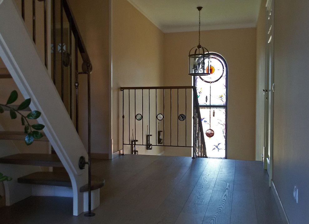 Foto de escalera en U tradicional renovada de tamaño medio con escalones de madera, contrahuellas con baldosas y/o azulejos y barandilla de metal