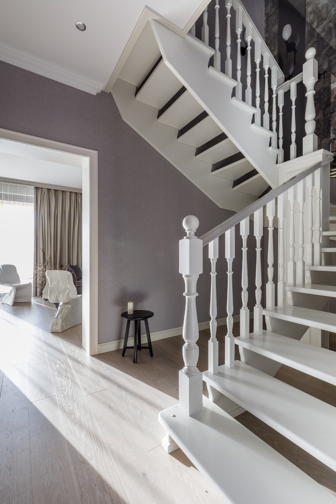 Стильный дизайн: изогнутая лестница в стиле неоклассика (современная классика) с деревянными ступенями и деревянными перилами без подступенок - последний тренд