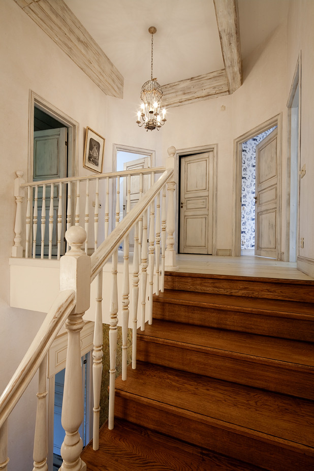 На фото: изогнутая деревянная лестница в стиле шебби-шик с деревянными ступенями