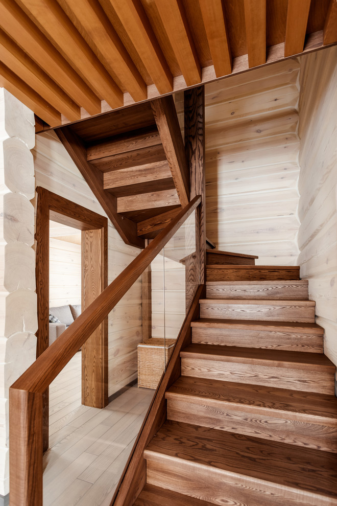 Стильный дизайн: маленькая лестница в современном стиле с крашенными деревянными ступенями, крашенными деревянными подступенками и стеклянными перилами для на участке и в саду - последний тренд