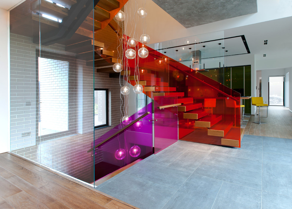 Свежая идея для дизайна: п-образная лестница в современном стиле с стеклянными перилами без подступенок - отличное фото интерьера