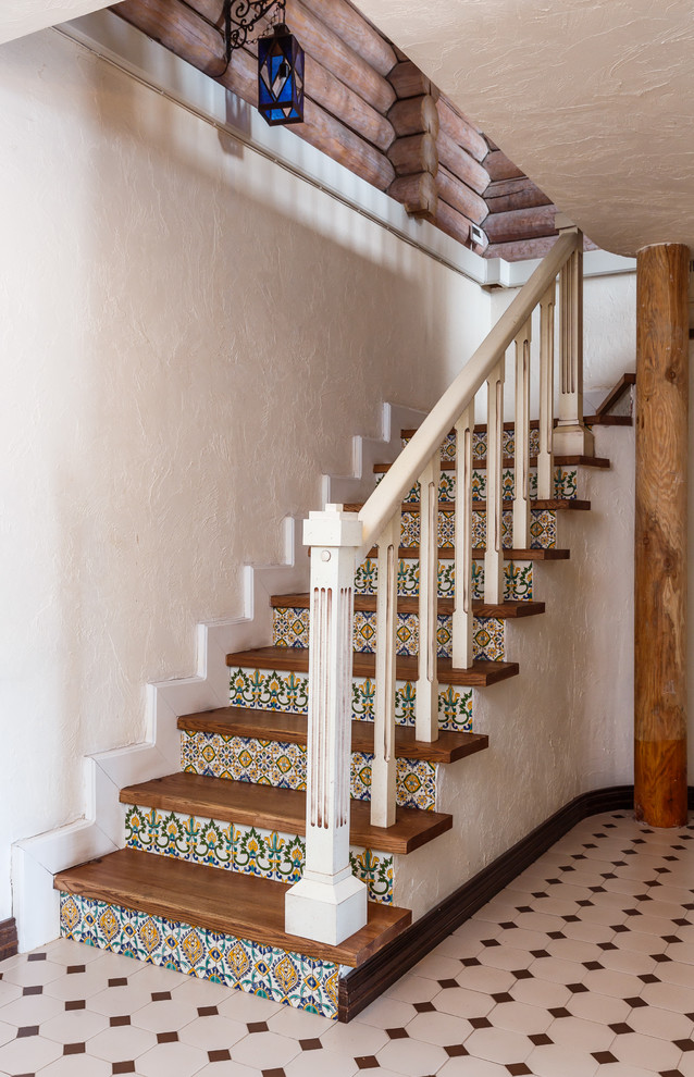 Пример оригинального дизайна: угловая лестница в стиле кантри с деревянными ступенями, подступенками из плитки и деревянными перилами
