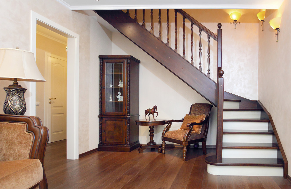 Idée de décoration pour un escalier peint tradition en L avec des marches en bois.