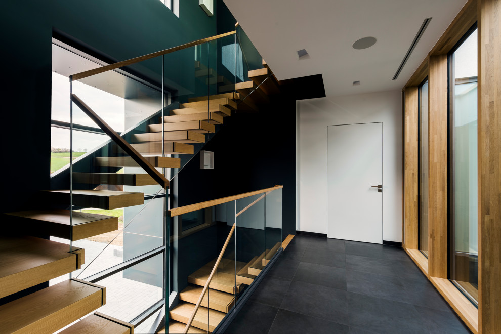 Идея дизайна: угловая лестница в современном стиле с стеклянными перилами без подступенок