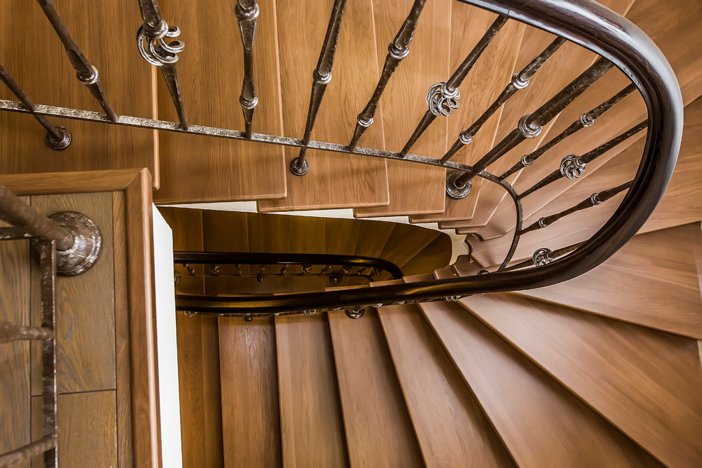 Пример оригинального дизайна: изогнутая лестница среднего размера в классическом стиле с деревянными ступенями и деревянными перилами