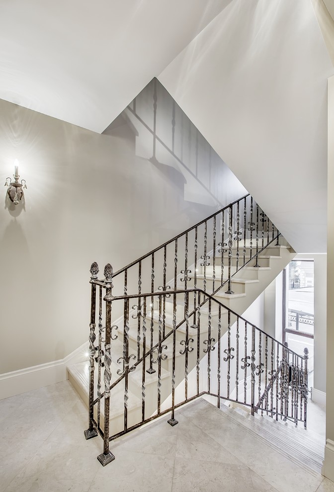 Réalisation d'un escalier tradition en U et marbre de taille moyenne avec des contremarches en marbre.