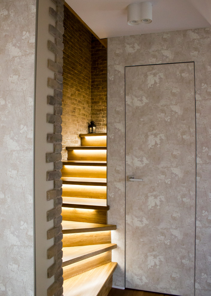 На фото: маленькая п-образная лестница в современном стиле с крашенными деревянными ступенями и крашенными деревянными подступенками для на участке и в саду