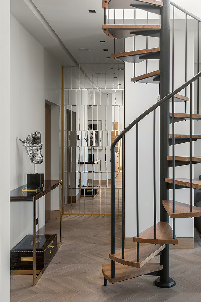 На фото: винтовая лестница в современном стиле с деревянными ступенями и металлическими перилами без подступенок с