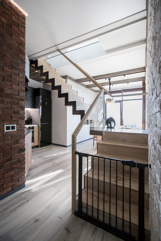 Ejemplo de escalera en L contemporánea con escalones de madera, contrahuellas de madera y barandilla de vidrio