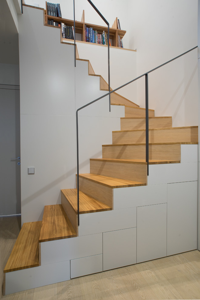 На фото: п-образная деревянная лестница среднего размера в современном стиле с деревянными ступенями и кладовкой или шкафом под ней с