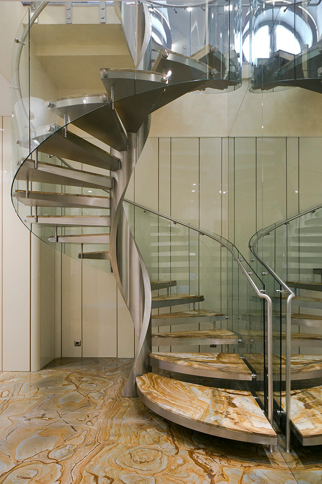 На фото: винтовая лестница среднего размера в современном стиле с мраморными ступенями и металлическими перилами