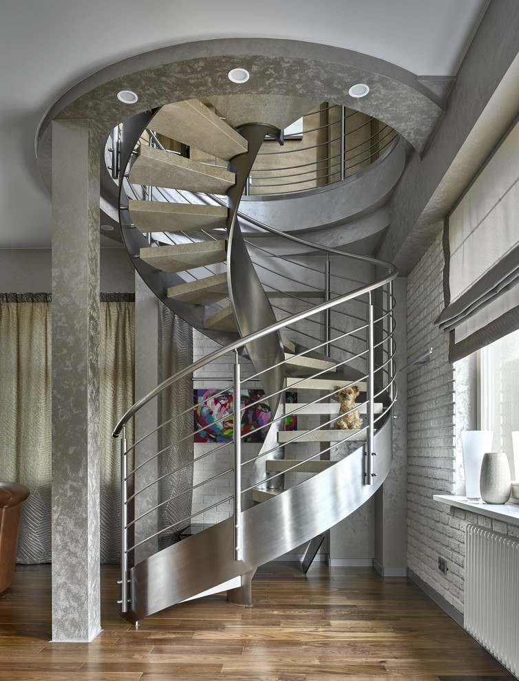 Стильный дизайн: изогнутая лестница в стиле лофт с металлическими перилами без подступенок - последний тренд