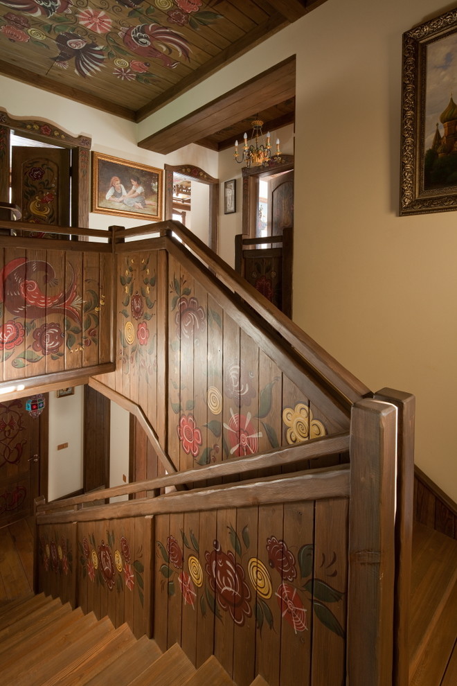 На фото: п-образная деревянная лестница в стиле кантри с деревянными ступенями и деревянными перилами с