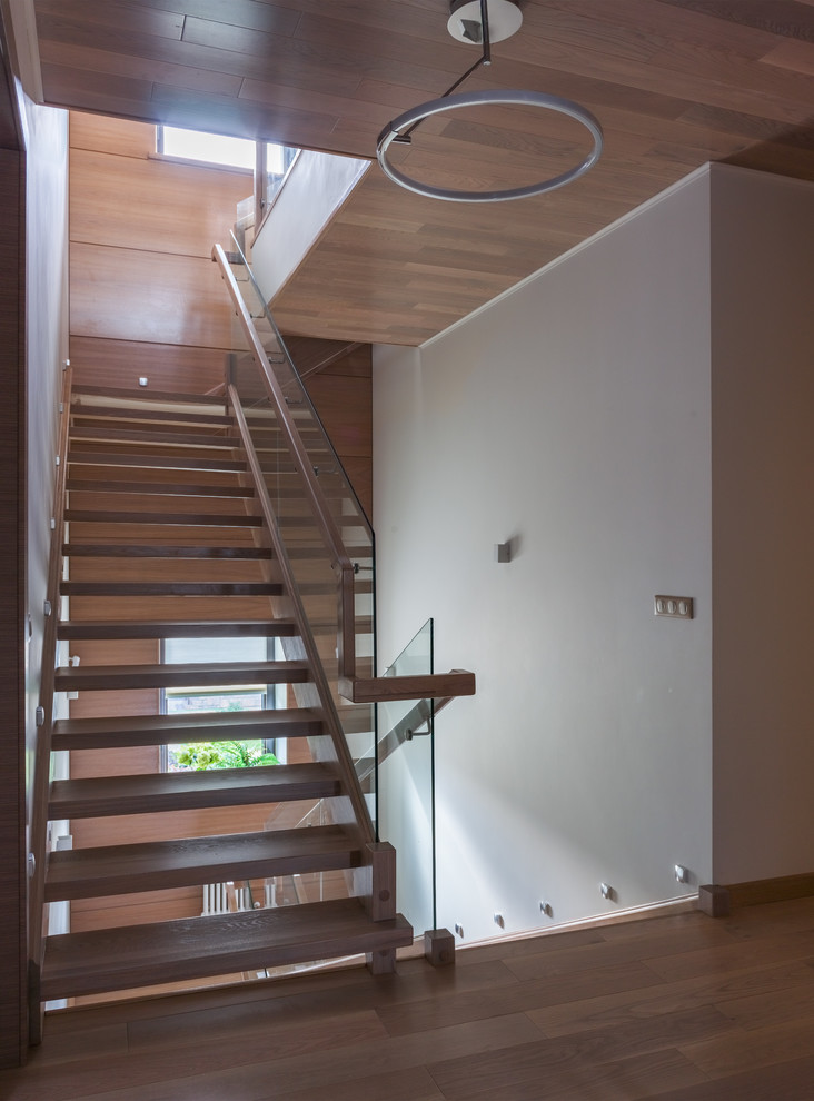 Idéer för funkis u-trappor i trä, med öppna sättsteg och räcke i glas
