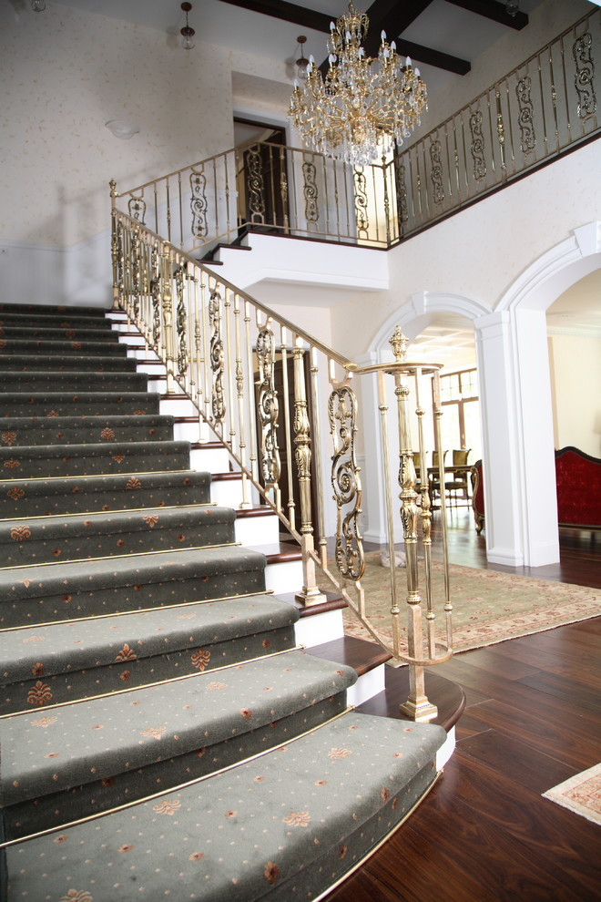 Diseño de escalera recta tradicional grande con escalones de madera, contrahuellas de hormigón y barandilla de metal