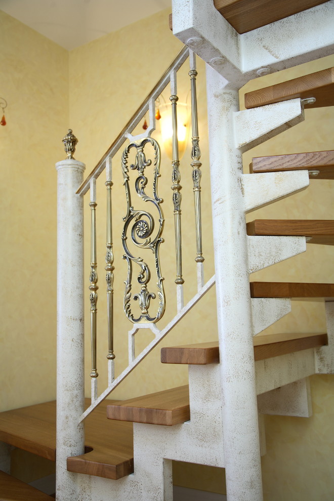 Diseño de escalera en L tradicional grande con escalones de madera y barandilla de metal