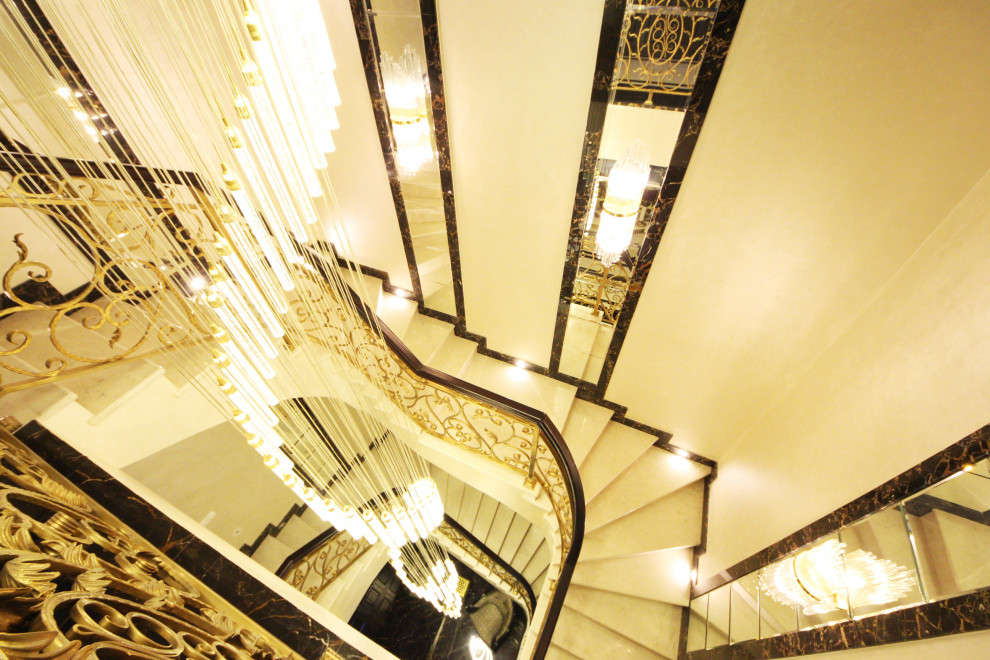 На фото: большая п-образная лестница в стиле фьюжн с мраморными ступенями, подступенками из мрамора, металлическими перилами и обоями на стенах с