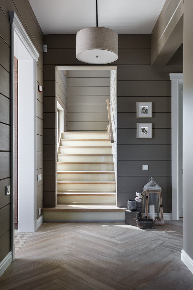 На фото: угловая лестница среднего размера в современном стиле с крашенными деревянными ступенями, стеклянными подступенками и деревянными перилами