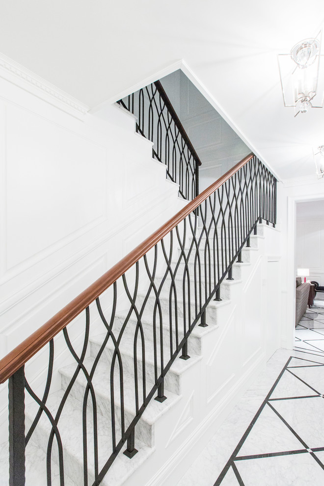 Стильный дизайн: п-образная лестница в классическом стиле с мраморными ступенями, подступенками из мрамора и перилами из смешанных материалов - последний тренд
